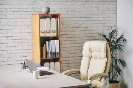 loft-style-office-with-laptop-sitting-desk-executive-chair-document-folders-shelves